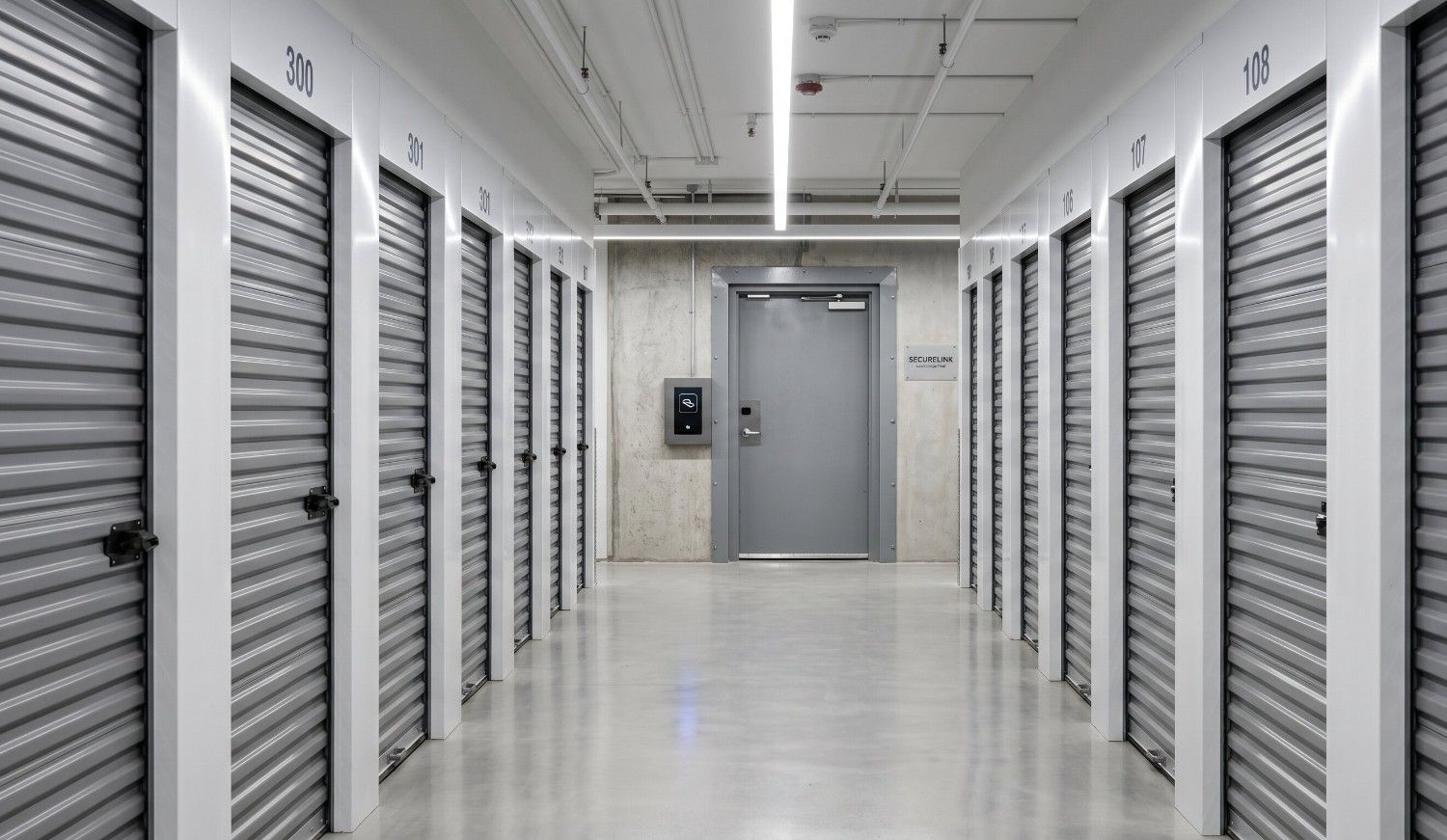 Clean, well-lit self storage facility corridor with card-access door panel visible